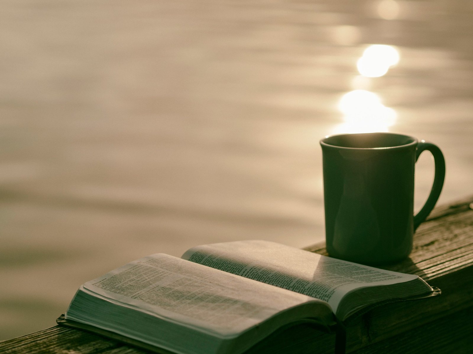 green ceramic mug beside book